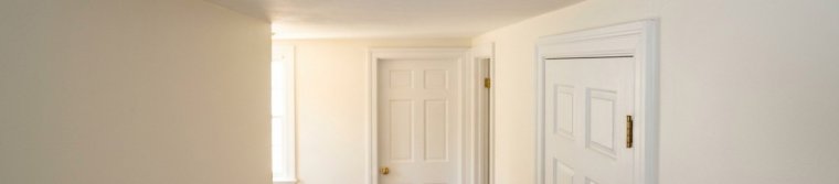 Smoke alarm on a hallway ceiling outside bedroom doors